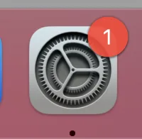 macOS System Preferences icon in the dock showing a pending notification badge
